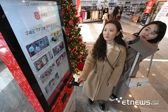 지난해 연말을 맞아 불우이웃을 돕기 위한 구세군 자선냄비가 전국에 설치된 가운데 디지털 자선냄비가 등장해 눈길을 끌고 있다. 지난해 12월 18일 서울 서대문구 구세군회관에 설치된 휘슬러코리아 기증 디지털 키오스크형 자선냄비에 시민들이 신용카드를 이용해 기부를 하고 있다. 김민수기자 mskim@etnews.com