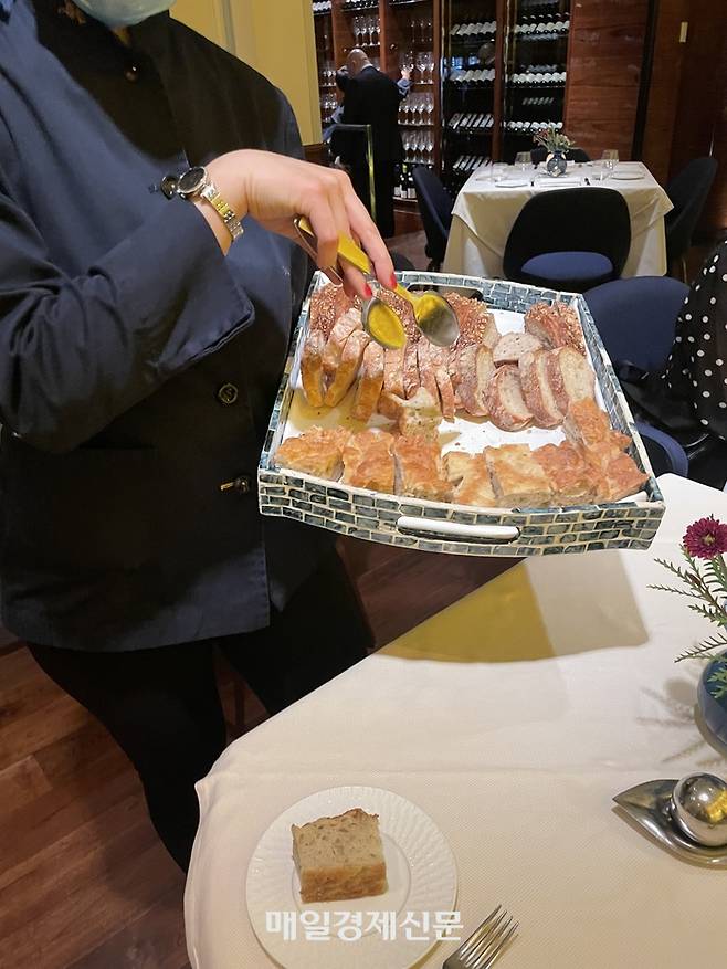 마레아에서 서버가 식전빵 3종류를 서빙하고 있다.