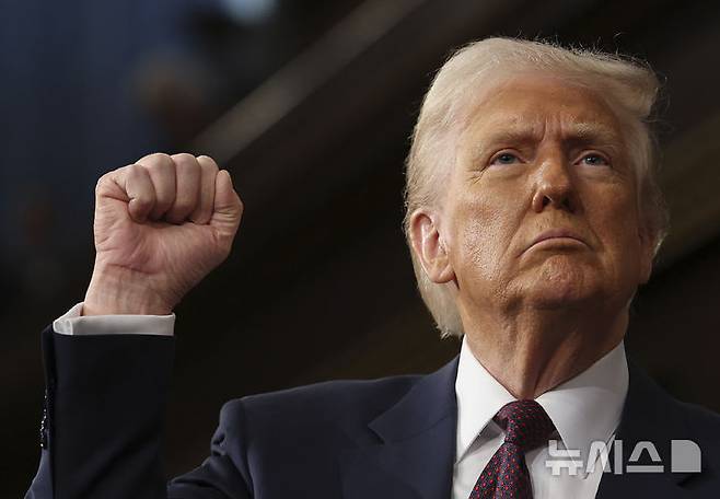 [워싱턴=AP/뉴시스]도널드 트럼프 미국 대통령이 4일(현지 시간) 미국 워싱턴DC 국회의사당에서 의회 상하원 합동 연설을 진행하며 주먹을 들어보이고 있다. 2025.03.05.