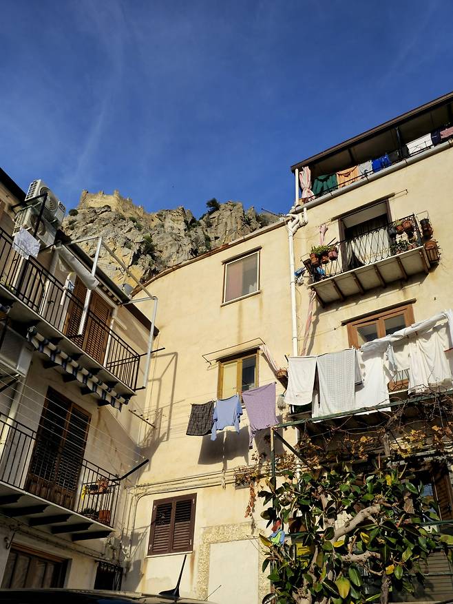 빨래가 내걸린 체팔루 골목 풍경과 로카 디 체팔루.