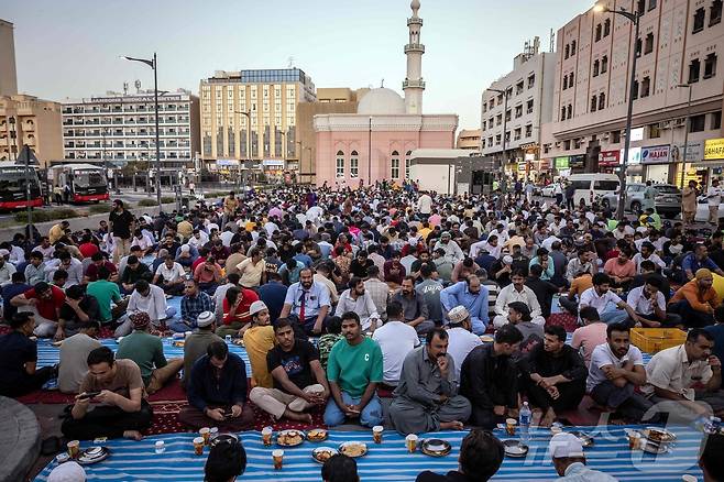 무슬림 신자들이 두바이에서 금식월인 라마단 기간 동안 일몰 시 매일 금식을 마치는 저녁 식사인 '이프타르' 를 앞두고 모여 있다.ⓒ AFP=뉴스1