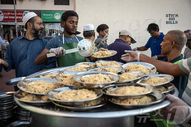 무슬림의 금식월인 라마단 기간에 두바이에서 한 자원봉사자가 단체 이프타르 식사(이슬람교도 일몰 시 일일 금식을 마치는 저녁 식사) 준비를 하고 있다.  ⓒ AFP=뉴스1