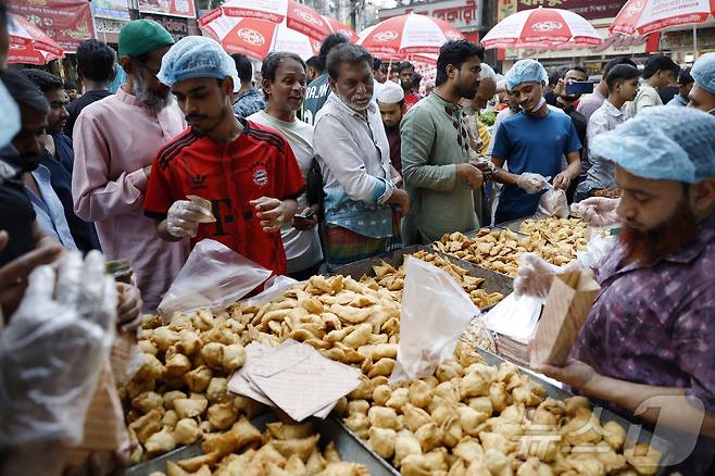 무슬림들이 방글라데시 다카의 라마단 성월 동안 초크 바자르 임시 이프타르 시장에서 이프타르 식사를 구입하고 있다. ⓒ 로이터=뉴스1
