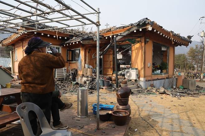▲ 7일 오후 경기도 포천시 이동면 노곡리 공군 전투기 오폭 사고 현장에서 피해 주민이 파손된 집을 보며 물을 마시고 있다 [연합뉴스]