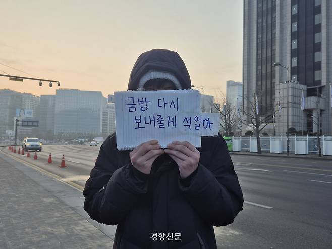 윤석열 대통령이 석방된 다음날인 9일 오전 6시20분쯤 서울 종로구 광화문 서십자각에서 철야 집회에 나선 유윤재씨(24)가 직접 쓴 손팻말을 들고 있다. 이예슬 기자