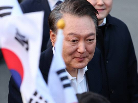 서울구치소에서 석방된 윤석열 대통령이 8일 서울 한남동 관저 앞에 도착, 차량에서 내려 지지자들과 인사를 나누고 있다. 연합뉴스