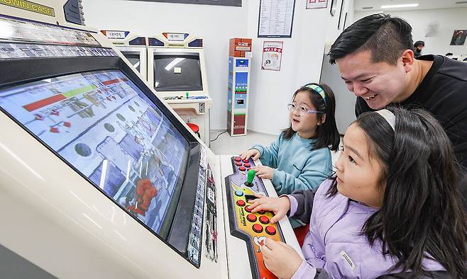 서울 동대문구 청량오락실에서 아버지와 두 딸이 즐겁게 스트리트 파이터 2 게임을 즐기고 있다.