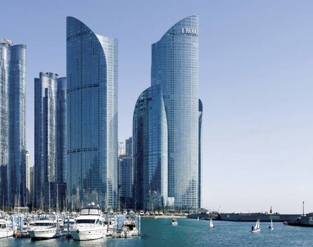 부산 해운대구 수영만 요트경기장에서 바라본 파크하얏트 부산 전경. 고층 유리 외관이 푸른 바다와 어우러져 세련된 도시 풍경을 연출한다. 마린시티 스카이라인을 배경으로 정박한 요트들이 럭셔리한 분위기를 더하고 있다. 파크하얏트 부산 제공