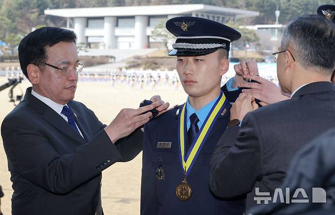 [청주=뉴시스] 조수정 기자 = 최상목 대통령 권한대행 부총리 겸 기획재정부 장관이 12일 청주 공군사관학교에서 열린 제73기 졸업 및 임관식에서 대통령상을 수상한 안주선 신임 소위에게 계급장을 달아주고 있다. (대통령실통신사진기자단) 2025.03.12. chocrystal@newsis.com