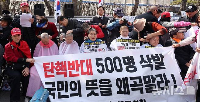 [서울=뉴시스] 김선웅 기자 = 헌재의 윤석열 대통령에 대한 탄핵심판 선고가 임박한 13일 서울 종로구 헌법재판소 앞에서 친 윤 성향 시민들이 탄핵을 반대하며 삭발을 하고 있다. 2025.03.13. mangusta@newsis.com