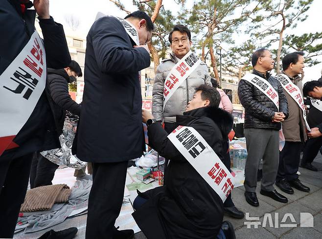 [서울=뉴시스] 김진아 기자 = 한국사 강사 전한길 씨가 국민의힘 기독인회 의원들과 14일 서울 종로구 헌법재판소 앞에서 '탄핵 각하 길' 걷기 기자회견에 앞서 어깨띠를 두르고 있다. 2025.03.14. bluesoda@newsis.com
