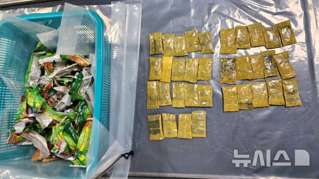 [제주=뉴시스] 제주세관 등이 지난달 23일 제주국제공항에서 외국인 마약 밀수 사범이 여행용 가방 내 과자 봉지에 숨긴 필로폰을 적발하고 있다. (사진=제주지방검찰청 제공) 2025.03.14. photo@newsis.com