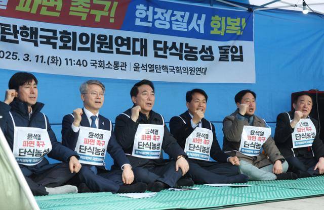 윤석열탄핵국회의원연대 소속 의원들이 11일 오후 서울 종로구 경복궁 서십자각 인근 농성장에서 윤석열 대통령 파면 촉구 및 헌정수호를 위한 단식 농성에 돌입하며 구호를 외치고 있다. 왼쪽부터 한창민 사회민주당, 민형배·박수현 더불어민주당, 윤종오 진보당, 김준혁·강득구 민주당 의원. 뉴시스