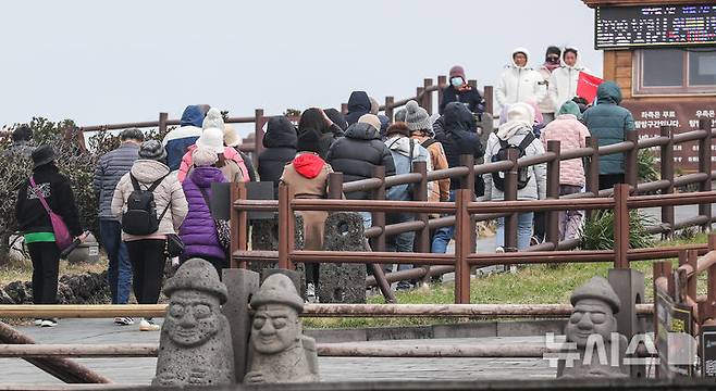 [서귀포=뉴시스] 우장호 기자 = 꽃샘추위가 찾아온 16일 오후 제주 서귀포시 성산읍 성산일출봉을 찾은 내·외국인 관광객들이 궂은 날씨에도 탐방로를 걸어가고 있다.   기상청에 따르면 북쪽에서 찬 공기가 남하하면서 18일까지 기온이 평년보다 3~6도 가량 낮아 추운 날씨가 이어질 전망이다. 2025.03.16. woo1223@newsis.com