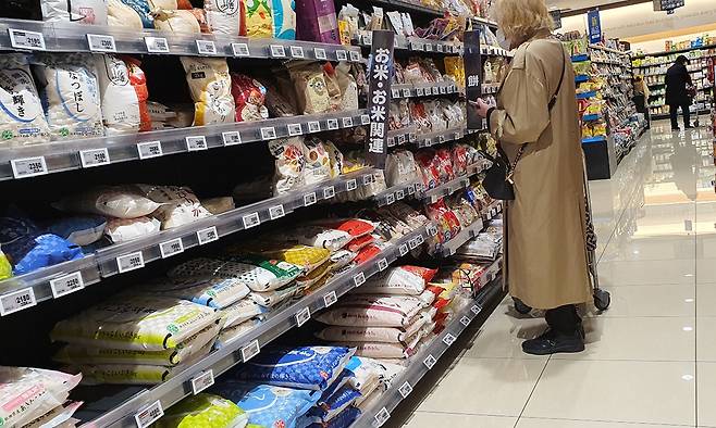 12일 일본 도쿄 신주쿠구의 한 대형마트를 찾은 소비자가 쌀과 쌀로 만든 상품을 살펴보고 있다.