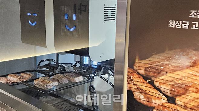 13일 서울 용산구의 고깃집 ‘용돼지’에서 고기 굽는 AI 로봇이 삼겹살을 굽고 있다.(사진=김세연기자)