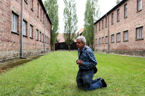 폴란드 남부 오시비엥침에 있는 아우슈비츠 수용소를 방문한 관람객이 2차 대전 당시 나치에 희생된 유대인을 위해 기도하고 있다. [EPA]