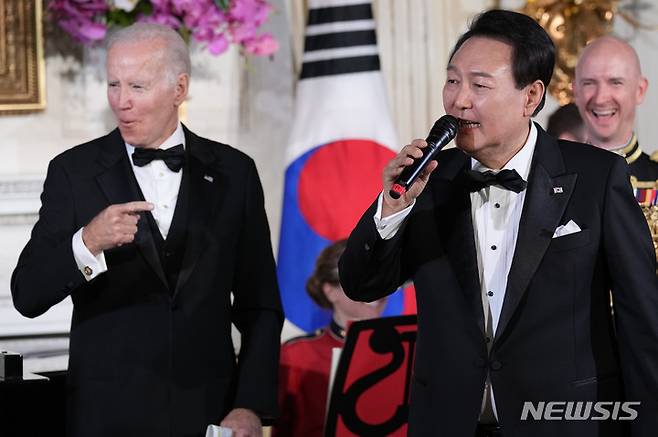 [워싱턴=AP/뉴시스] 윤석열 대통령이 2023년 4월26일(현지 시간) 백악관에서 열린 국빈만찬을 마친 후 조 바이든 당시 대통령과 무대에 올라 미국의 싱어송라이터 돈 맥클린의 '아메리칸 파이'를 부르고 있다. 바이든 전 대통령이 퇴임 직전 한국을 민감국가로 지정한 사실이 뒤늦게 알려지면서 배경에 관심이 쏠린다. 2025.03.17.