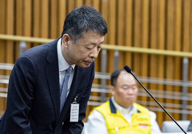 김광일 MBK 파트너스 부회장이 18일 오전 서울 여의도 국회 정무위원회에서 열린 홈플러스·MBK 파트너스 및 삼부토건 관련 긴급 현안질의에서 의원 질의에 답변을 하고 있다. 김병주 회장은 회의에 불참했다. 뒤쪽은 홈플러스 노조 최철한 사무국장.