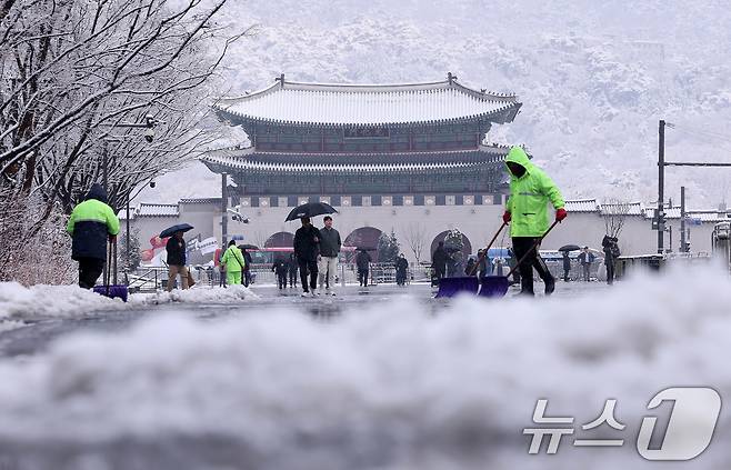 난데없는 3월 대설주의보가 발효된 18일 오전 서울 광화문광장에서 관계자들이 눈을 치우고 있다. 2025.3.18/뉴스1 ⓒ News1 박지혜 기자