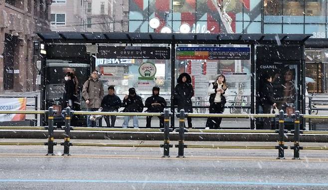 18일 오전 7시30분 눈이 내리고 있는 서울 강남역 인근 버스정류장에서 시민들이 버스를 기다리고 있다. 변선진 기자