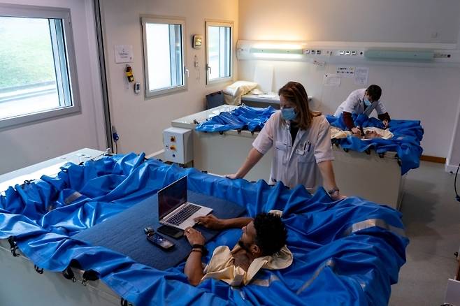 무중력 상태가 인체에 미치는 영향을 실험하기 위해 머리와 팔을 빼고 물 속에서 열흘 간 생활한 참가자. 사진=유럽우주국(ESA)