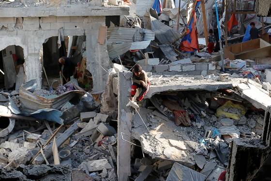 18일 가자지구 남부 칸유니스에서 한 팔레스타인 소년이 이스라엘의 공습으로 파괴된 건물 잔해에 앉아 있다. 로이터= 연합뉴스연합뉴스, 무단 전재-재배포, AI 학습 및 활용 금지〉