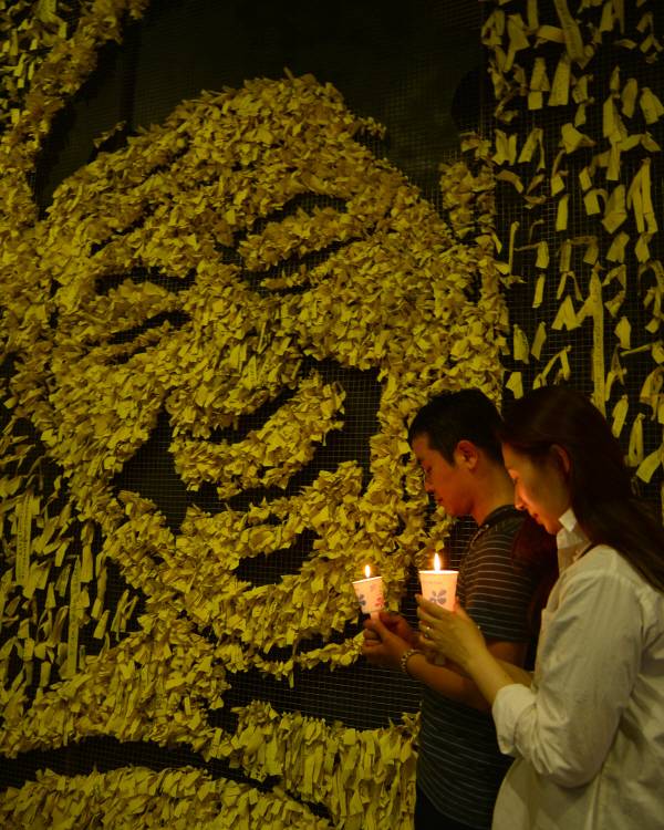 고 노무현 전 대통령 4주기 추모식을 하루 앞둔 22일 오후 김해 봉하마을을 찾은 한쌍의 부부가 노대통령 추모관에서 촛불을 밝히며 고인의 넋을 기리고 있다./이진우 프리랜서