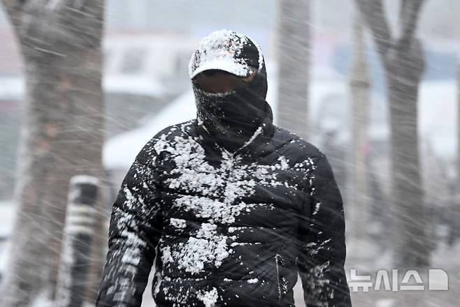 [광주=뉴시스] 김혜인 기자 = 절기상 춘분을 이틀 앞두고 광주지역에 눈이 내린 18일 오전 광주 남구 진월동 한 공원에서 시민이 눈을 맞으며 걸어가고 있다. 2025.03.18. hyein0342@newsis.com