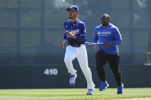 LA 다저스 무키 베츠가 지난 10일 시범경기 오클랜드전을 앞두고 트레이너와 훈련하고 있다. AP연합뉴스