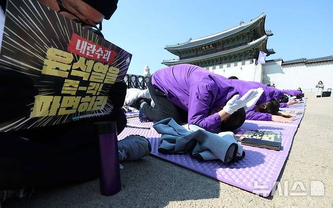 [서울=뉴시스] 고범준 기자 = 10.29 이태원 참사 유가족협의회, 시민대책회의 관계자들이 19일 서울 종로구 광화문 월대 옆에서 윤석열 대통령 파면 기원 159배를 하고 있다. 2025.03.19. bjko@newsis.com