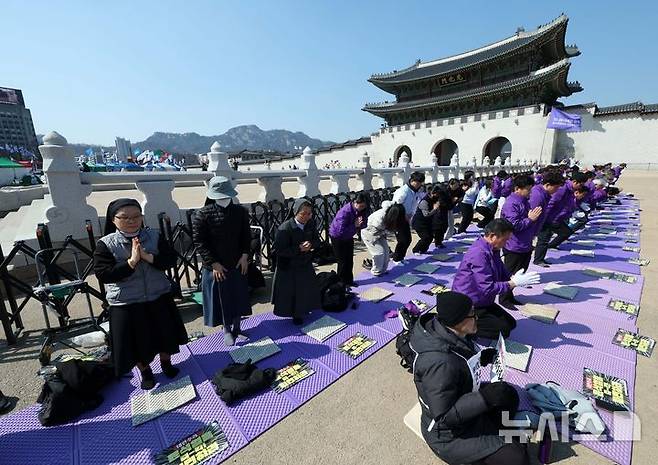 [서울=뉴시스] 고범준 기자 = 10.29 이태원 참사 유가족협의회, 시민대책회의 관계자들이 19일 서울 종로구 광화문 월대 옆에서 윤석열 대통령 파면 기원 159배를 하고 있다. 2025.03.19. bjko@newsis.com