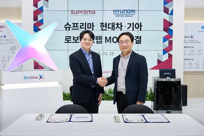 지난 19일 경기 고양 킨텍스에서 현동진 현대차·기아 로보틱스랩장 상무(오른쪽)와 김한철 슈프리마 대표가 로봇 친화 빌딩 구축 확대를 위한 업무협약식 후 기념촬영을 하고 있다. 현대차그룹 제공