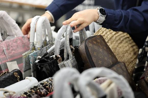 명동 비밀매장에서 ‘짝퉁’ 명품 적발 - 20일 오전 서울 중구 서울시청 남산 별관에서 서울시 민생사법경찰국 직원이 위조 상품을 판매한 일당 2명으로부터 압수한 가방 등 물품을 정리하고 있다. 이들은 명동 일대에서 벽으로 위장된 계단으로 이어진 30여평 규모의 비밀 매장을 만들고 외국인을 상대로 위조 상품을 판매한 혐의를 받고 있다. 2025.2.20 뉴스1