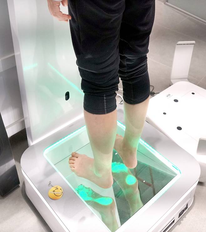 족저경 위에 올라 발을 정밀하게 측정하고 있다.