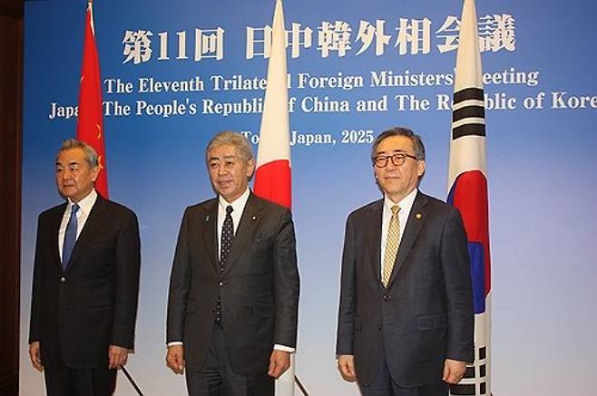 조태열 한국 외교부 장관(오른쪽)과 왕이 중국 공산당 중앙외사판공실 주임(외교부장 겸임, 왼쪽), 이와야 다케시 일본 외무상이 한중일 외교장관 회의 하루 전인 21일 도쿄시내 호텔에 마련된 만찬장에 들어가기 전 기념 촬영을 하고 있다.  연합뉴스