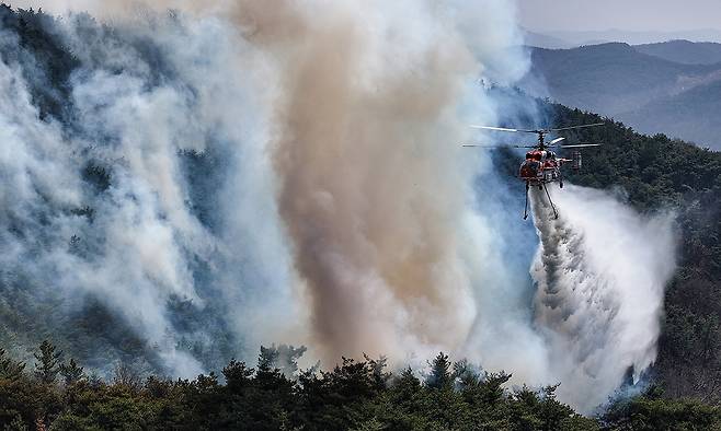 경북 의성군 대형 산불 발생 이틀째인 23일 의성군 산불 발화지점 인근 야산에서 산림청 헬기가 산불 진화를 하고 있다. 연합뉴스