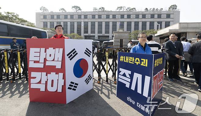 '12·3 비상계엄' 관련 한덕수 국무총리의 탄핵 심판 사건 선고를 하루 앞둔 23일 서울 종로구 헌법재판소 앞에서 국민의힘, 더불어민주당 관계자들이 각각 탄핵 찬·반 1인 시위를 하고 있다. 2025.3.23/뉴스1 ⓒ News1 이승배 기자