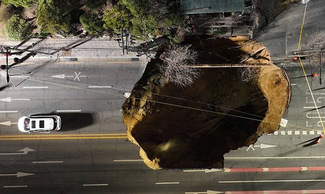 24일 저녁 서울 강동구 명일동 대명초교 사거리 인근에서 대형 땅꺼짐(싱크홀) 사고가 발생해 도로 한가운데가 크게 파손돼 있다. 김영원 기자 forever@hani.co.kr