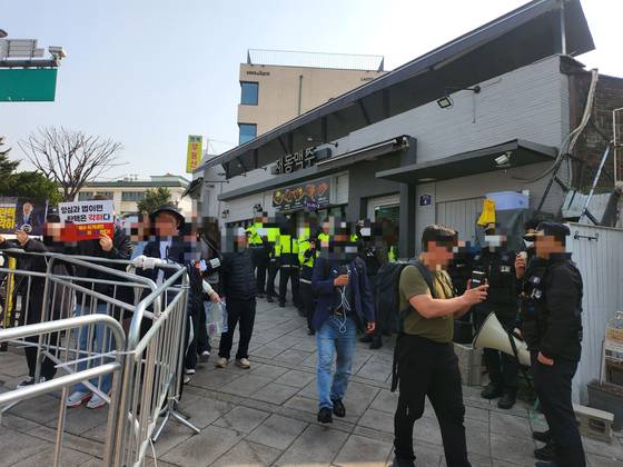 경찰이 24일 헌재 인근 재동초 앞에 모인 1인 시위를 표방한 집회 참가자들을 강제 해산하기 위해 경고방송을 하고 있다. 김서원 기자