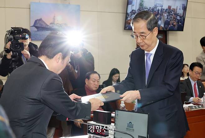 한덕수 국무총리가 지난달 25일 국회 내란혐의 국정조사특위에서 증인선서문을 안규백 위원장에게 제출하고 있다. 박민규 선임기자