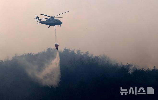 [의성=뉴시스] 이무열 기자 = 경북 의성군 산불 발생 사흘째인 24일 안평면 삼춘리 한 야산에서 산불진화헬기가 진화작업을 하고 있다. 2025.03.24. lmy@newsis.com