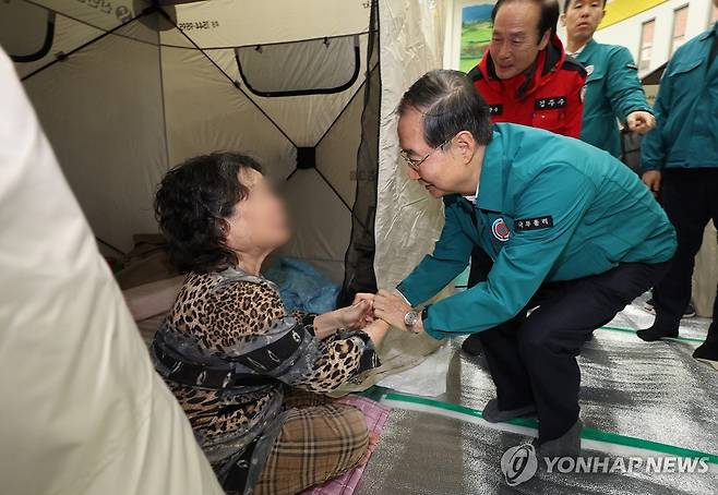 산불 이재민 위로하는 한덕수 권한대행 (의성=연합뉴스) 윤관식 기자 = 한덕수 대통령 권한대행 국무총리가 24일 경북 의성군 의성체육관에 마련된 산불 대피소를 방문해 이재민을 위로하고 있다. 2025.3.24 psik@yna.co.kr