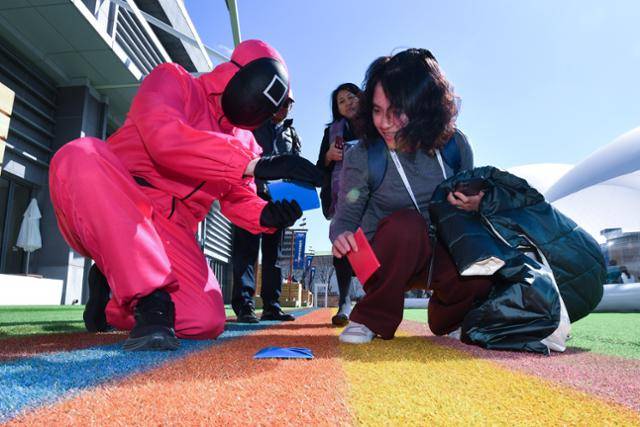 APEC 2025 KOREA (SOM1) 고위관리회의 첫날인 지난달 24일 회의장인 경북 경주시 보문단지 내 경주컨벤션센터(HICO) 야외에 마련된 투명 돔 공연장 앞에서 대만 관계자들이 영화 오징어 게임에 나오는 캐릭터와 함께 딱지치기를 하고 있다. 경주=뉴스1