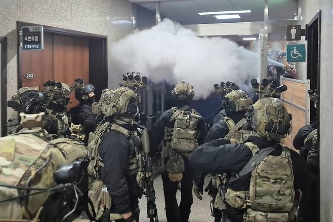 지난해 12월 4일 새벽 국회 본청에 진입한 군 병력이 국민의힘 당대표실쪽에서 본회의장 으로 진입하려 하자, 국회 직원들이 소화기를 뿌리며 진입을 막고 있다. 연합뉴스