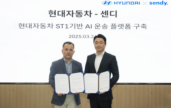 Oh Ki-yong, managing director of Hyundai Motor's domestic software vehicle business division, and Yeom Sang-jun, CEO of Sendy, pose for a photo after signing a memorandum of understanding to build an AI-powered logistics platform based on Hyundai's ST1 vehicle at the automaker's headquarters in Seoul on March 24. [HYUNDAI MOTOR]