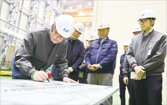 구자균 LS일렉트릭 회장이 지난해 KOC전기 증설 공장의 초고압 변압기 초도 생산을 기념하는 사인보드에 서명하는 모습. (LS일렉트릭 제공)