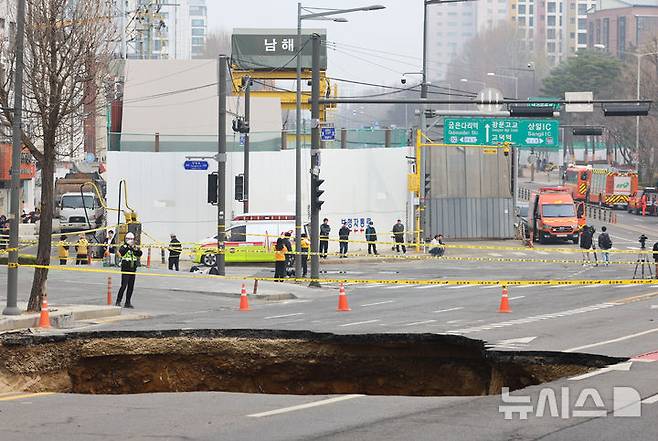 [서울=뉴시스] 황준선 기자 = 25일 오전 서울 강동구 명일초등학교 인근 도로에서 전날 발생한 싱크홀(땅 꺼짐) 사고 현장이 통제되고 있다.현재 싱크홀 아래에는 사고 당시 현장을 지나던 오토바이 운전자가 매몰돼 있는 것으로 알려졌다. 2025.03.25. hwang@newsis.com
