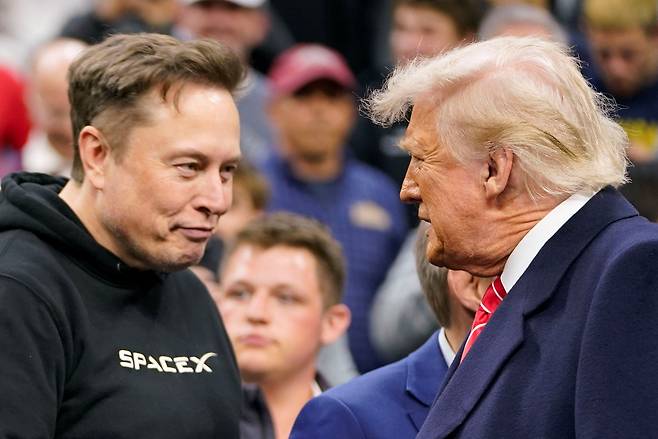 Tesla CEO Elon Musk greets U.S. President Donald Trump as they attend the NCAA men's wrestling championships in Philadelphia, Pennsylvania, on March 22. [REUTERS/YONHAP]