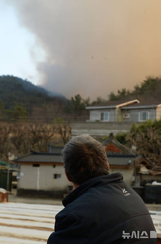 [울산=뉴시스] 배병수 기자 = 울산시 울주군 온양읍 산불이 발생한지 닷새째인 26일 오후 마을주민이 불꽃연기를 바라보고 있다. 2025.03.26.bbs@newsis.com.